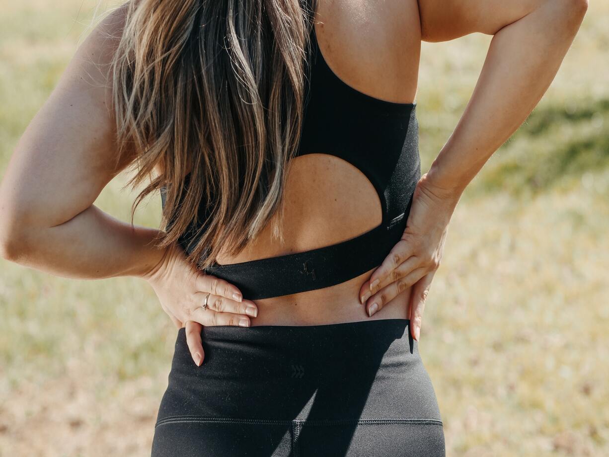 Athletic Woman Holding Lower Back With Sciatica Pain